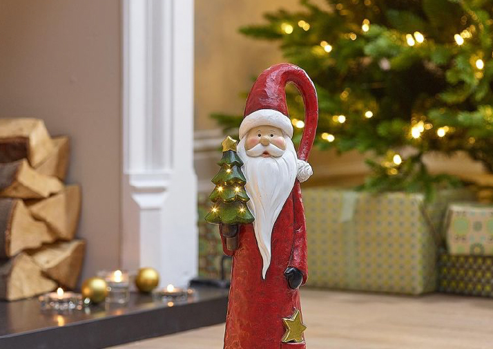 An image of a small Santa figure decoration holding a christmas tree