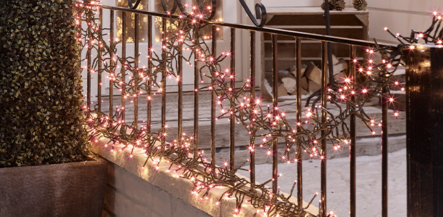 white christmas cluster lights on an outdoor railing and pathway