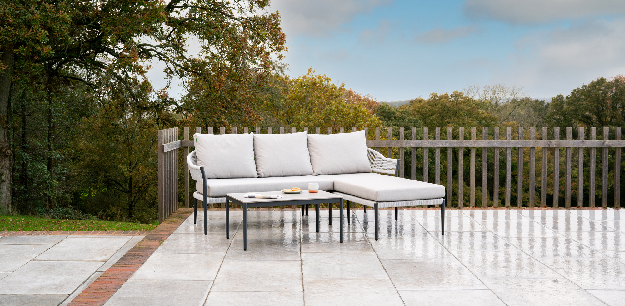 Light grey sofa with chaise on left wide, wide a rectangular coffee table.