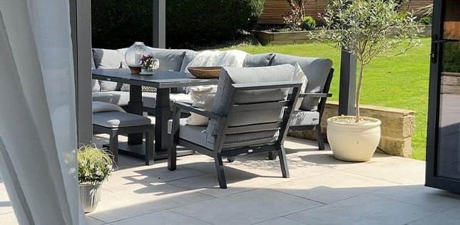 metal corner sofa set with dining chair under a metal pergola